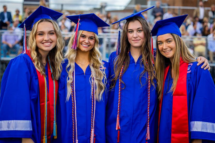 Students in blue robes graduate